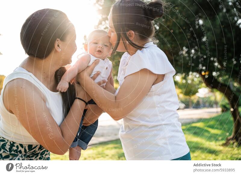 Lesbisches Paar küsst jungen Sohn an einem sonnigen Tag im Freien lesbisch Baby Familie Mutter gleichgeschlechtlich Liebe Freude Säugling Eltern modern