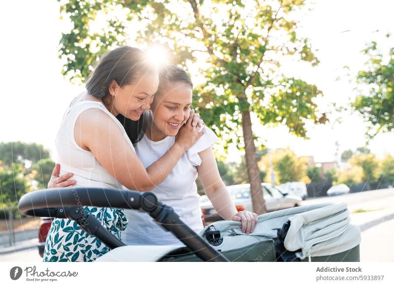 Generiertes Bild Familie lesbisch Paar Sohn Kinderwagen Park Angebot Moment Starrer Blick Liebe Zuneigung im Freien sonnenbeschienen Frau umarmend Fröhlichkeit