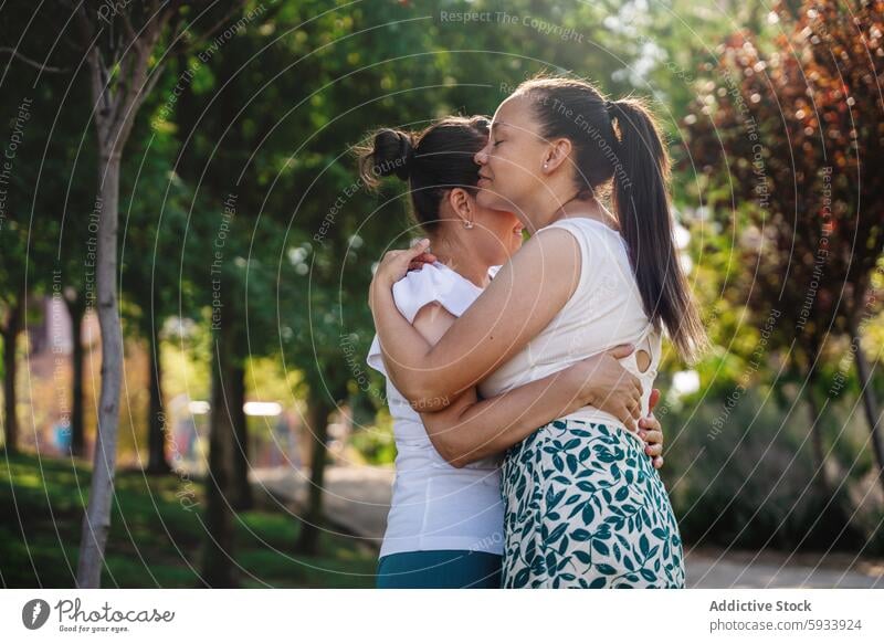 Lesbisches Paar umarmt sich in einem sonnenbeschienenen Park lesbisch Sonnenlicht Umarmen Freude Angebot Frau Liebe Fröhlichkeit Partnerschaft Zusammensein