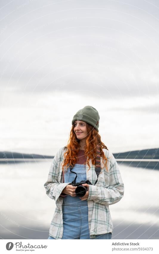 Outdoor-Fotograf fängt heitere Momente am See ein Frau Fotokamera im Freien Gelassenheit lässig Bekleidung Fokus Ausdruck Natur Landschaft Wasserlandschaft