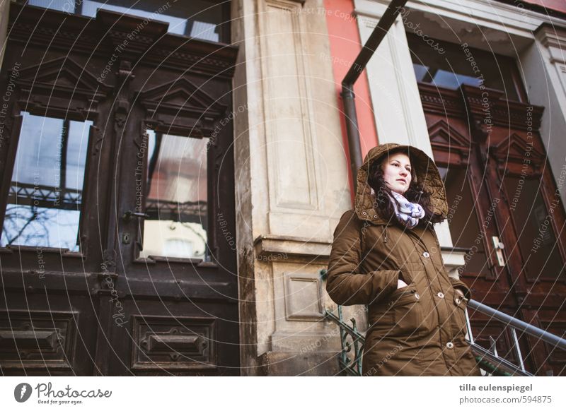 außer Haus Winter feminin Junge Frau Jugendliche 1 Mensch 18-30 Jahre Erwachsene Stadt Fassade Tür Mantel frieren Blick warten kalt braun Gelassenheit geduldig