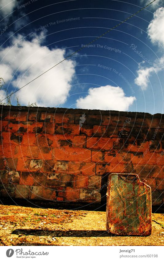 Sprengstoff. Kanister Benzin Mauer Wolken Anschlag Backstein Rost Himmel