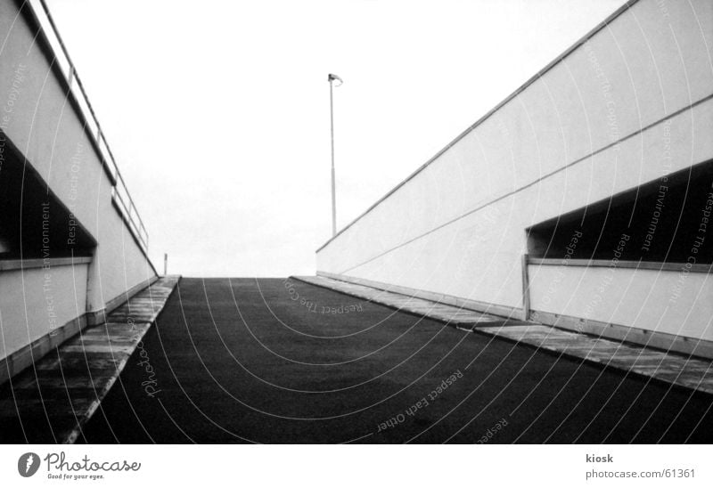 parkebene no.3 Parkhaus Autobahnauffahrt Mauer Laterne diagonal Schwarzweißfoto polapan