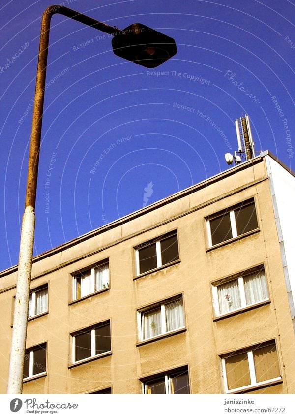 Zuhause. Haus Laterne Block Plattenbau Gardine Wohnung Osten Fenster dreckig hässlich Lampe Antenne grau beige Sozialgesetz Pfosten Himmel blau Häusliches Leben