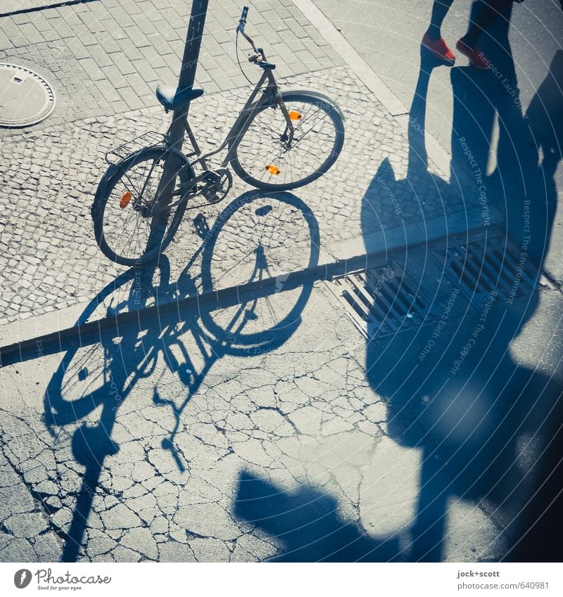 tritt ins Licht mit Schattenspiel Fuß Kreuzberg Fußgänger Straßenkreuzung Bürgersteig Gully Fahrrad Reflektor Riss gehen Irritation parken angeschlossen