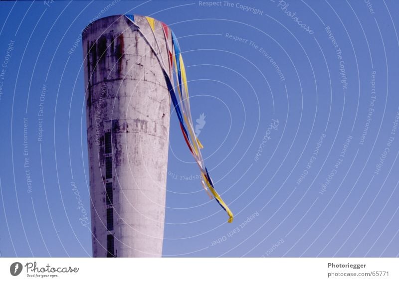 insgesamt sah es aus der Ferne aus... Wasserturm Fahne Schnur mehrfarbig grau weiß Fenster kegelförmig rot gelb Wind Turm Himmel blau lustig was auch immer