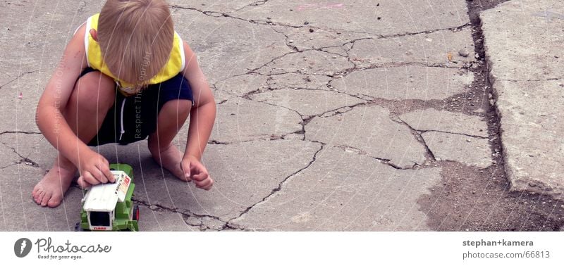 // kleine Kinder spielen gern Spielzeug Spielen Traktor Mähdrescher Hose blond Barfuß Sommer grün schwarz gelb Finger Kieselsteine Freizeit & Hobby Kindergarten