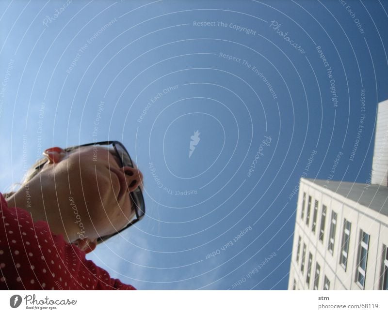 Frau vor Hochhaus Haus Block Stadt Sonnenbrille unten Himmel Schönes Wetter blau oben