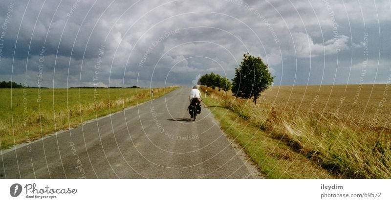 Biker Feld Wolken Fahrrad Ferien & Urlaub & Reisen fahren unterwegs Mobilität strampeln Wege & Pfade Himmel Ausflug Berge u. Gebirge Natur