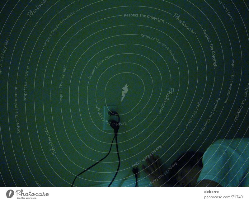 Wand in der Dämmerung mit Steckdose und einer auf dem Boden liegenden Person. Elektrizität Nacht grün dunkel schlafen Mensch Energiewirtschaft Müdigkeit Leben