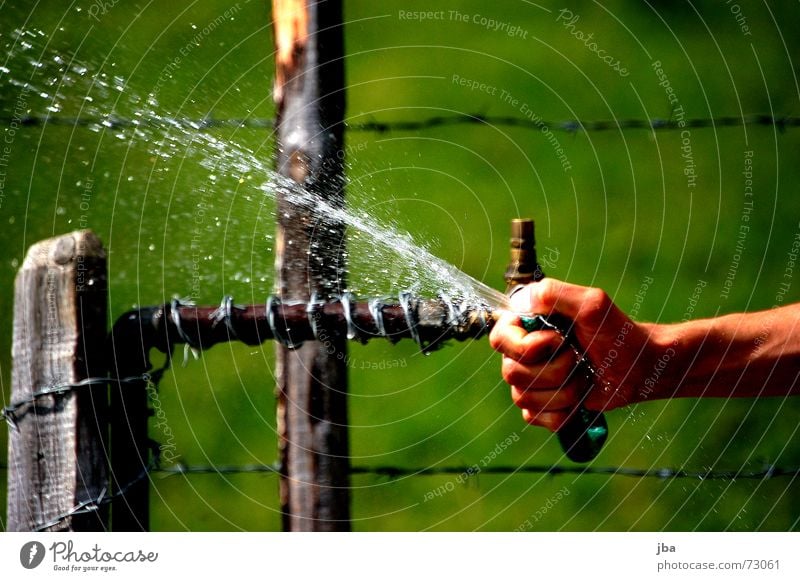 tut gut! Schlauch Brunnen Hand Daumen Finger Stacheldraht Zaun Draht Holz Pfosten nass kalt Kühlung feucht Gras grün Wiese Wasser spritzen Wassertropfen Arme