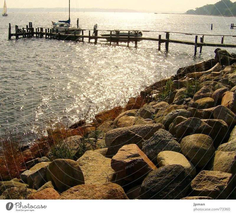 Abendsonne in Dänemark Wasserfahrzeug Steg Küste Reflexion & Spiegelung Berghang Physik Sonnenuntergang Segeln Stein Wärme