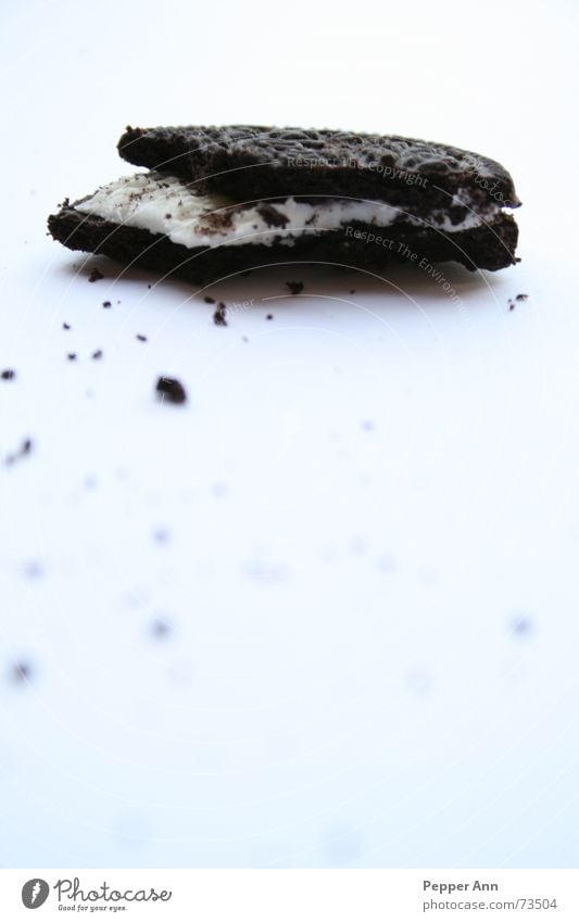 trauriger, einsamer...keks Oreo Keks braun Krümel Hälfte schwarz weiß frontal milchcreme halber keks Schatten beißen abgebissen Halbkreis Zuckerguß Sahne