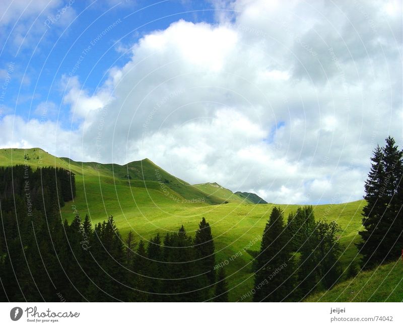 Bergwelt Wolken grün Baum Hügel wandern gehen Spaziergang Idylle Himmel Berge u. Gebirge Sonne Schatten ziehen Ferne