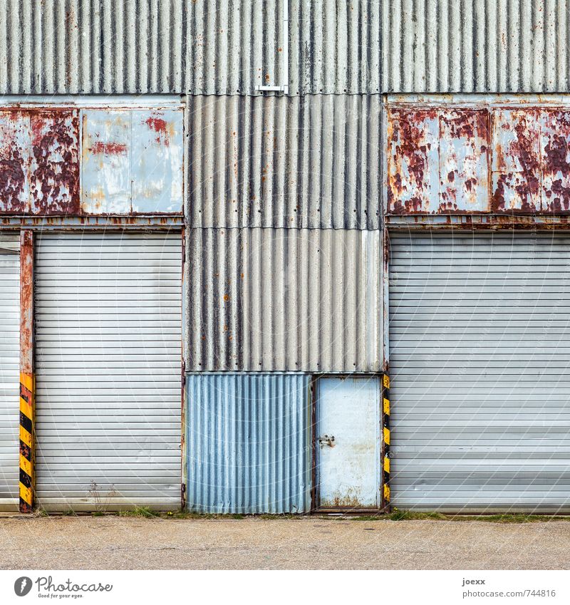 Portal geschlossen Fassade Tür Tor Metall alt hässlich retro blau braun gelb grau schwarz Vergänglichkeit Wellblechwand Linie Rost Patina Farbfoto