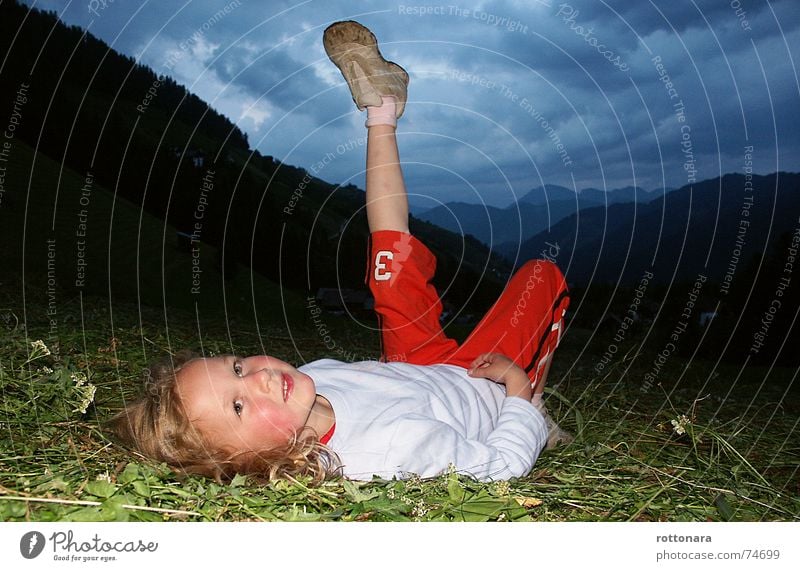 Der Himmel fällt runter... Mädchen Kind grinsen grün dunkel Gras Wiese Wolken rot Mensch lachen child Schatten Beine Abend blau