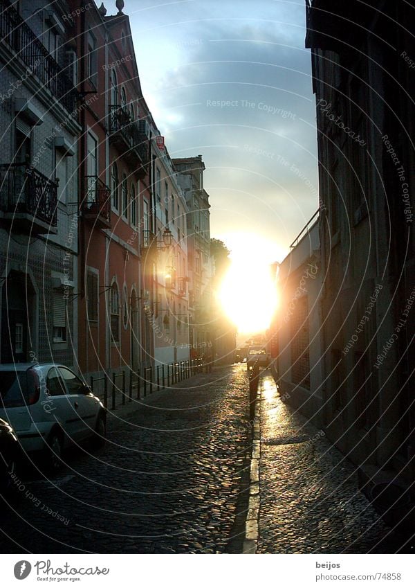 Ein Licht am Ende der Gasse parken eng Romantik Haus Fassade Balkon Wolken Watte Physik schön Sonnenuntergang Kopfsteinpflaster träumen ruhig Tiefgang