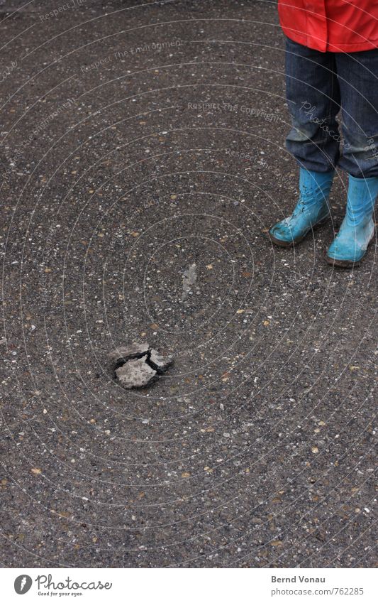 Dreiteiler gebrochen Stein Kind Gummistiefel schlecht Wetter Außenaufnahme Tag Asphalt Riss Teile u. Stücke Teilung steinig Jeanshose Hose stehen Blick Boden