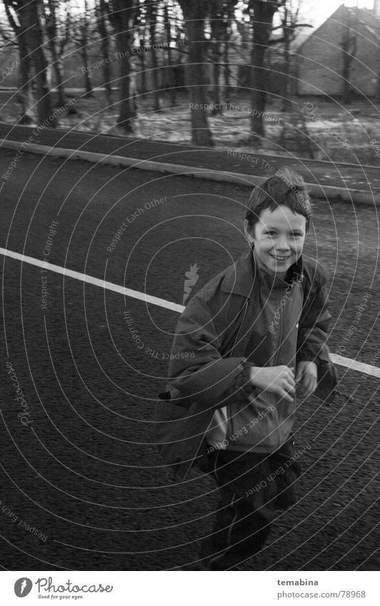 Boy Running Monochrom Riga grinsen Freude running suburb smiling white street Schwarzweißfoto