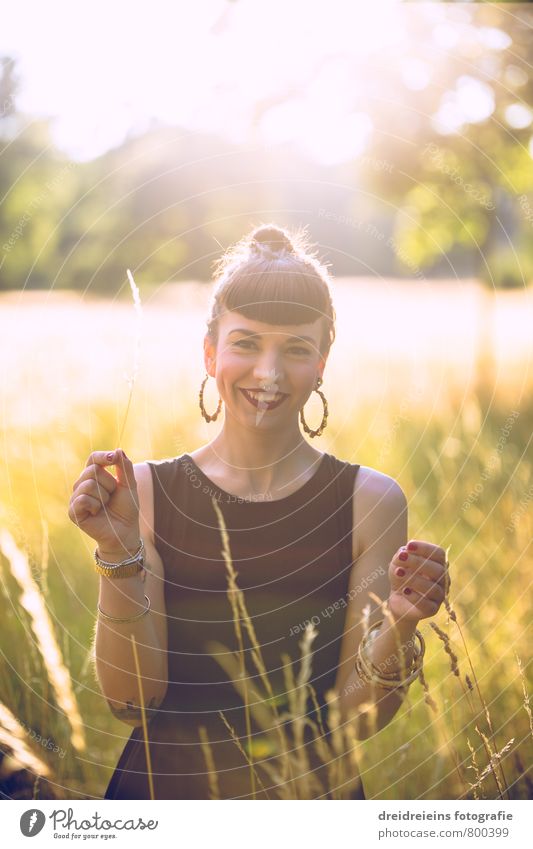 Sommerabend auf der Wiese feminin Junge Frau Jugendliche Erwachsene 1 Mensch Garten Park Kleid Ohrringe schwarzhaarig berühren Lächeln lachen Blick stehen