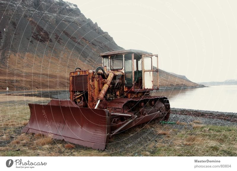 bulldoze the fjord away Planierraupe See Außenaufnahme Westfjord Baustelle vergangen Luft Bauarbeiter Rost Maschine kaputt Island Meer Gras Elektrisches Gerät