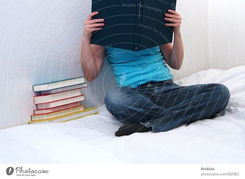 buchkopf No.2 begutachten Frau lesen lernen Buch Sichtschutz Hand Finger festhalten Wand Bett türkis T-Shirt Blick Schneidersitz Bettlaken Jeansstoff abweisend