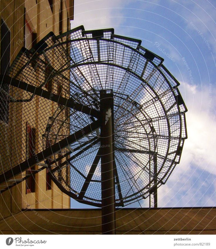 Wendeltreppe Metalltreppe Harrier Lebenslauf Spirale Karriere vertikal steil Froschperspektive Wolken Haus Wand Fenster Mauer aufsteigen Detailaufnahme