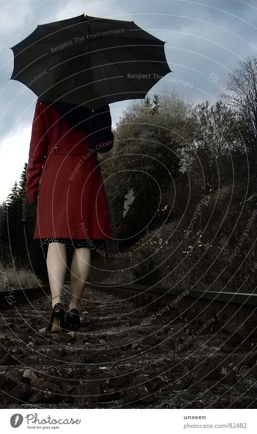 lass' laufen Frau Erwachsene Beine Natur Himmel Wolken Baum Gleise Mantel Regenschirm gehen rot Einsamkeit Spaziergang Farbfoto Gedeckte Farben Außenaufnahme