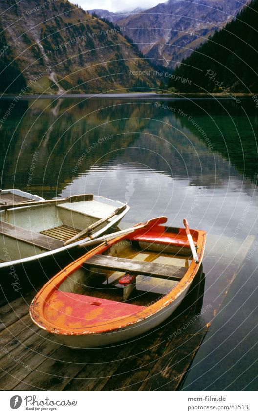 bergsee See Ruderboot Gebirgssee rot Wasserfahrzeug Erholung Berge u. Gebirge Schifffahrt klares wasser Alpen Natur Kontrast postkartenmotiv