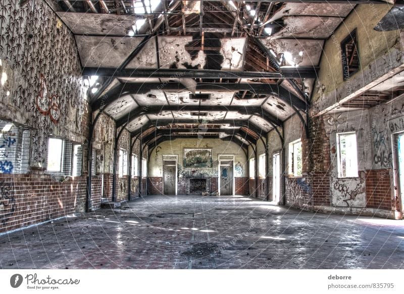 Blick auf den großen Saal in einem heruntergekommenen Gebäude mit Graffiti und zerbrochenen Fenstern. Menschenleer Haus Ruine Bauwerk Stein Beton Holz alt Armut