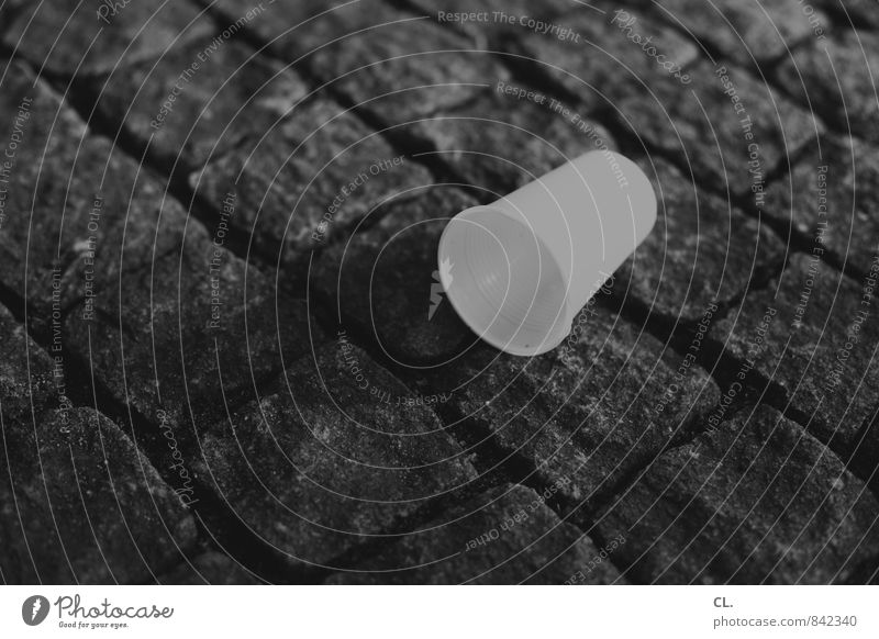 becher Erfrischungsgetränk Becher Straße Wege & Pfade Kunststoff verschwenden Müll Müllverwertung Müllentsorgung Kopfsteinpflaster Schwarzweißfoto Außenaufnahme