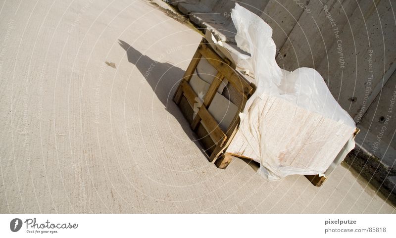 -> vom -> Holzkiste Schatztruhe aufräumen grau Wand Mauer Schattenspiel Wind Sandverwehung Sturm Abdeckung Folie massiv Stabilität kaputt gelb Orkan nass