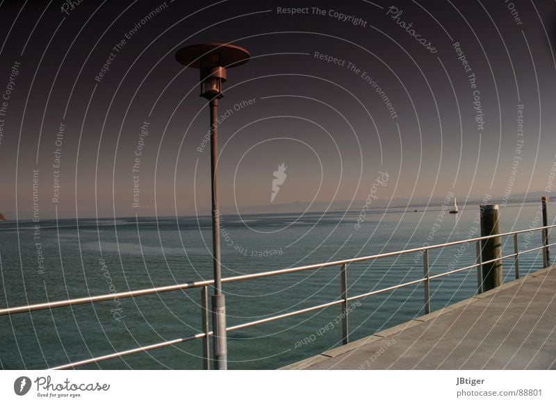 Sonnenbrillenzeit See Reling Segelboot Wasserfahrzeug ruhig Frieden Lampe Laterne Promenade Physik Meer Bodensee schneebedeckte Berge Geländer Ferne Freiheit