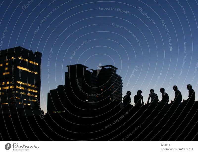 sechs junge Menschen sitzen im Gegenlicht der Abenddämmerung vor der Silhouette einer Großstadt (Melbourne) Sonnenuntergang Freiheit Dämmerung Freundschaft