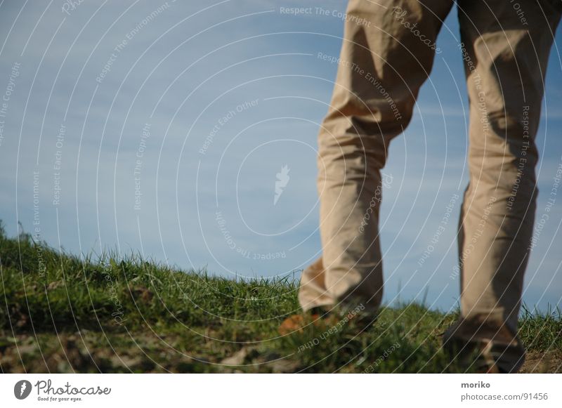 Sehnsucht Liebeskummer vermissen Trauer Aussicht Zukunft träumen Hoffnung Ferne Hügel Hose beige Schuhe Wolken schlechtes Wetter weiß Gras grün Verzweiflung