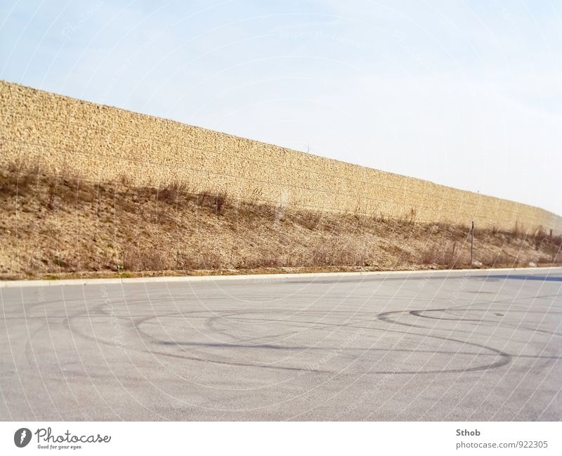 Lärmschutz und Reifenspuren Burnout PKW Wolkenloser Himmel Unkraut München Stadt Lärmschutzwand Mauer Wand Verkehr Straßenverkehr Autofahren Verkehrszeichen