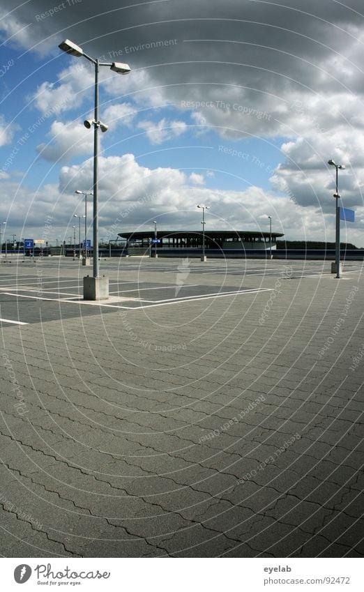 Unbeparkt: Auf jeden PKW kommen etwa 6,8 Parkplätze Lampe Laterne Licht Sommer Wolken grau graue Wolken Beton Parkplatz Streifen leer Tag Gebäude Haus