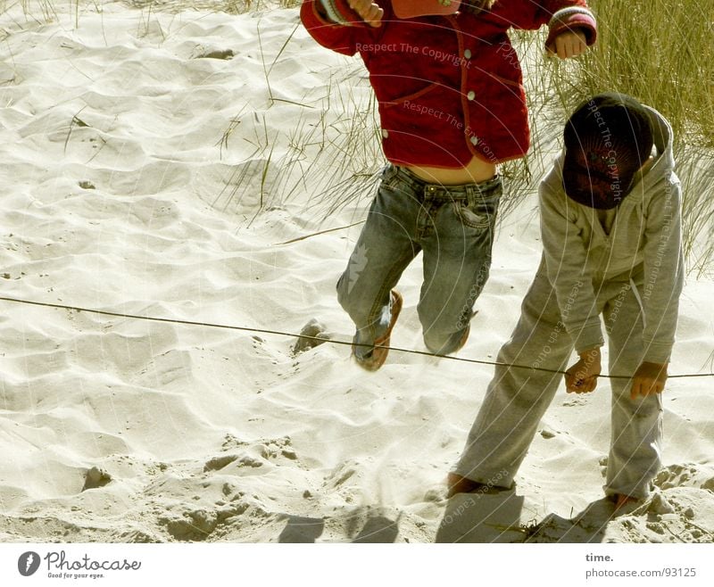 Übersprungshandlung Farbfoto Gedeckte Farben Außenaufnahme Tag Freude Freizeit & Hobby Spielen Ferien & Urlaub & Reisen Strand Kind Mädchen Junge Geschwister