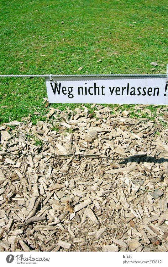 Weg nicht verlassen, geschrieben auf weissem Schild in Schwarz, über einer Wiese in der Natur Gras Wege & Pfade Zeichen Schriftzeichen Schilder & Markierungen