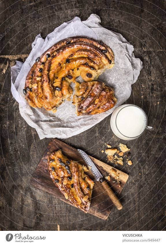 Geflochtene Kuchen mit Rosinen und Mandeln und Tasse Milch Lebensmittel Milcherzeugnisse Dessert Süßwaren Ernährung Frühstück Kaffeetrinken Bioprodukte