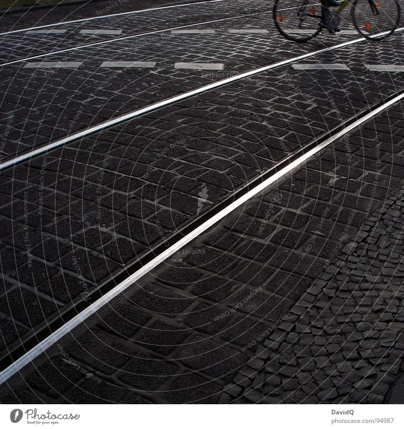 18:07 Asphalt Kopfsteinpflaster Fahrradweg Gleise weiß grau schwarz heimwärts Feierabend Verkehrswege Schwarzweißfoto Straße Wege & Pfade pseudo-schwarzweiß