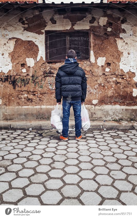 Junge mit Einkaufstaschen vor heruntergekommenes Haus kaufen Kind 8-13 Jahre Kindheit Herbst Winter Jacke alt stehen Armut authentisch einfach Gefühle Stimmung