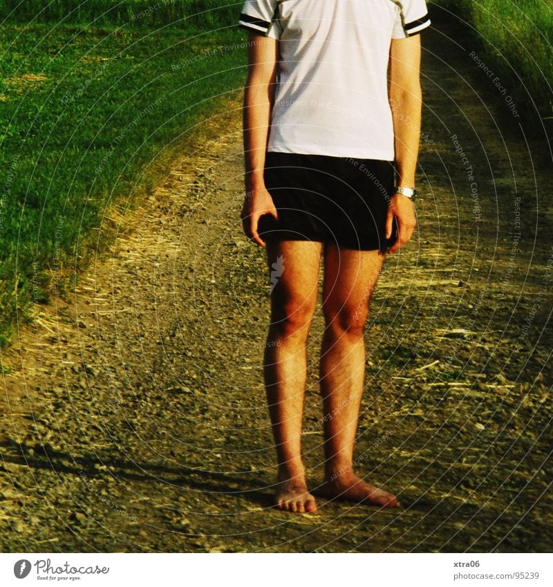 barfuß Mann Männerbein Gras grün T-Shirt Shorts Einsamkeit Barfuß wandern gehen stehen Mensch Beine Wege & Pfade Rasen Abend Müdigkeit Arme Schatten