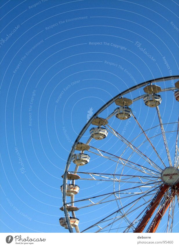 Der Blick hinauf zu einem Riesenrad mit blauem Himmel dahinter. gelb groß Jahrmarkt Karussell rund Freude Dinge hoch kreisen