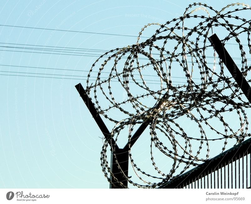 Antidemonstrantischer Schutzwall. Zaun Stacheldraht Käfig G8 Gipfel gefangen aussperren Nationale Sicherheit grau geschlossen Sperrzone Himmel blau eingezäunt