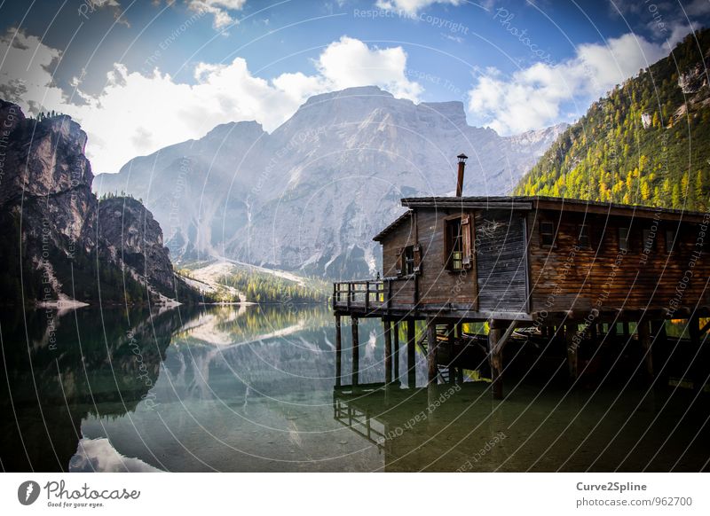 Haus am See Natur Landschaft Urelemente Wasser Himmel Wolken Schönes Wetter Felsen Berge u. Gebirge Gipfel Seeufer Dorf Menschenleer Hütte authentisch Holzhütte