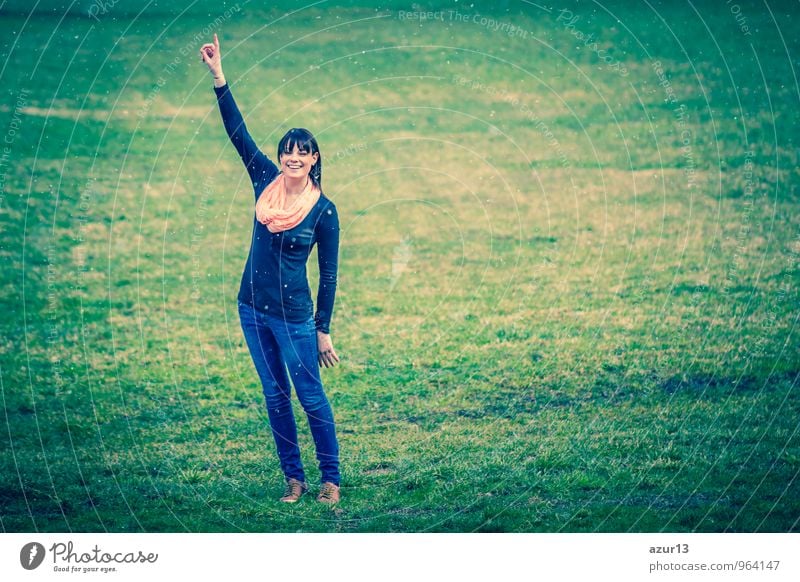 Ideen im Winter. Wunderschönes junges Mädchen streckt ihren Finger nach oben während es auf einer grünen Wiese schneit. Mensch Junge Frau Jugendliche Erwachsene