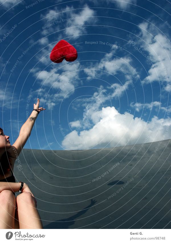 Fernbeziehung Frau Junge Frau fangen berühren himmelblau weiß Wolken schlechtes Wetter grau rot fliegen Symbole & Metaphern Kissen Herz Dekoration & Verzierung