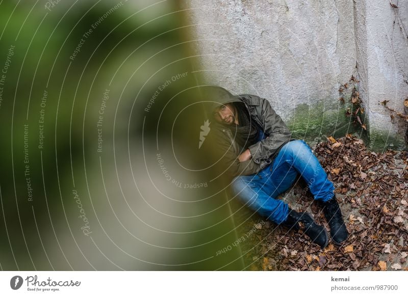 In der Ecke Mensch maskulin Junger Mann Jugendliche Erwachsene Leben Körper 1 18-30 Jahre Herbst Blatt Jeanshose Mantel Stiefel Kapuze liegen sitzen dunkel grün