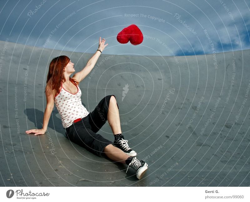 heart's desire Frau Junge Frau fangen berühren schlechtes Wetter Wolken Örtlichkeit Schuhe Chucks grau rot fliegen Schweben Symbole & Metaphern Kissen Herz